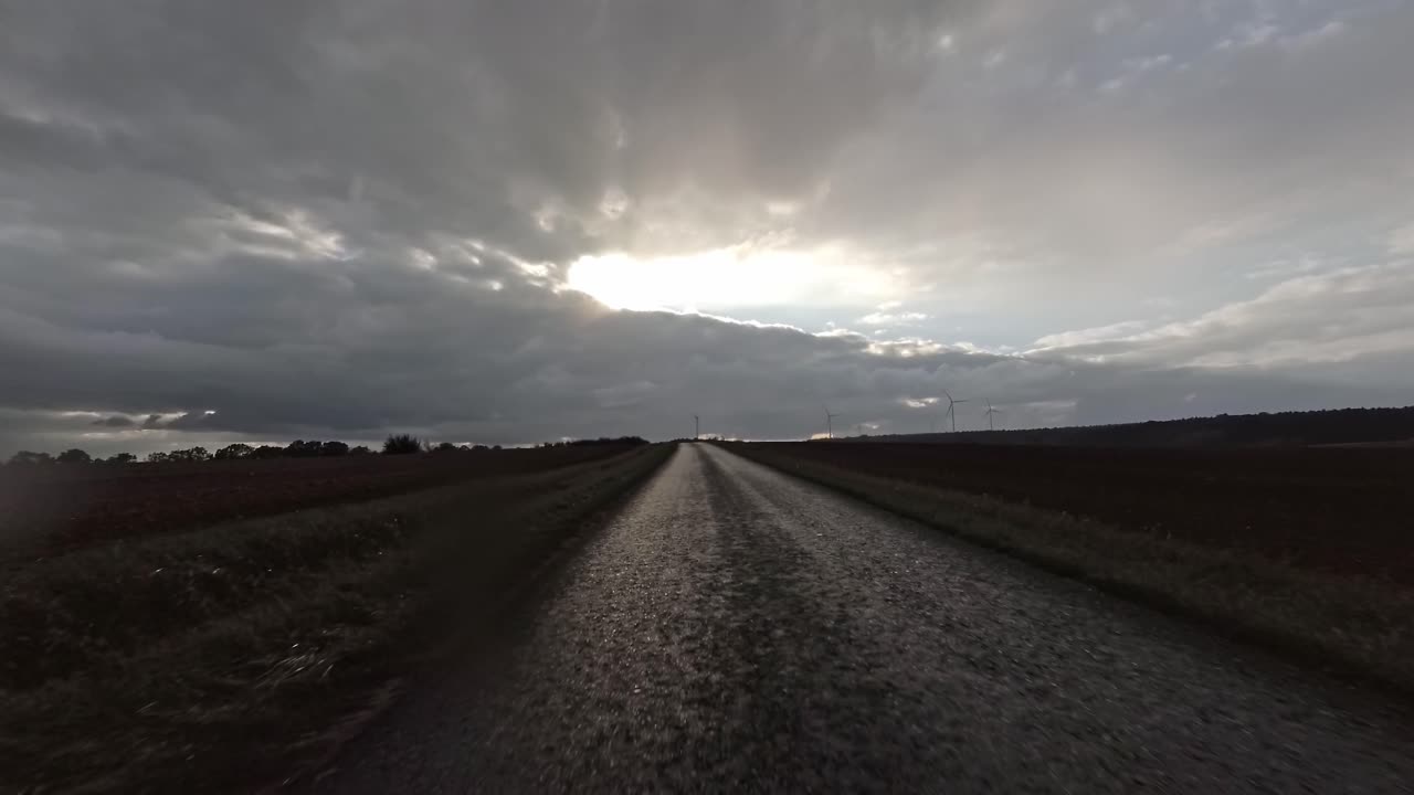 First person view of driving over a field path on a rainy day, 4k