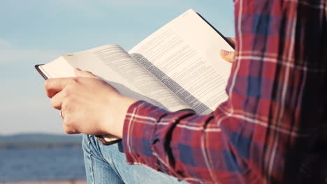 Close-up-of-The-Bible-with-lake-behind