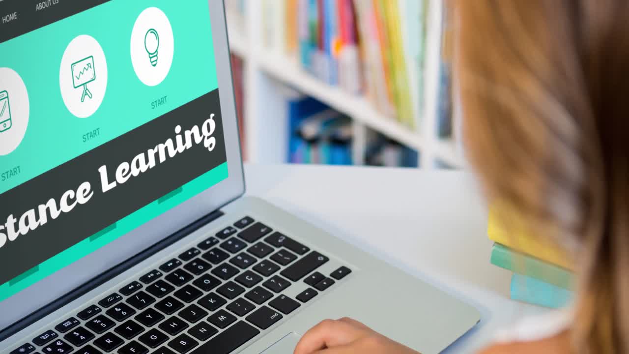 vista trasera de una niña usando una computadora portátil en la biblioteca de la escuela