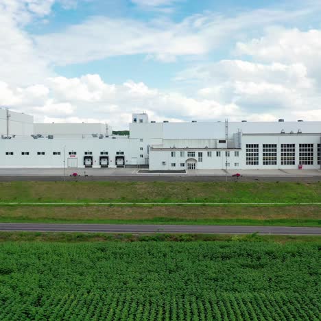 large innovative plant under the sky. modern industry with white buildings on field. front view. motion camera to the right