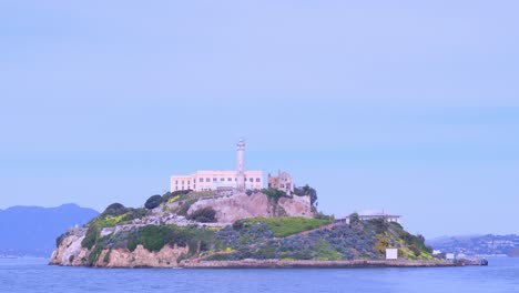 the iconic and historic alcatraz island is located in the beautiful san francisco bay. enjoy a beautiful, scenic view of alcatraz island showcasing its historic prison structure and iconic lighthouse