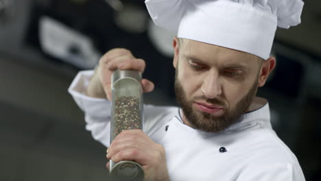 Retrato-Del-Chef-Cocinando-En-La-Cocina.-Primer-Chef-Salpicando-Comida-En-Cámara-Lenta.