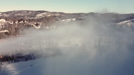 snow lance making snow at ski resort on winter day in saint-sauveur, quebec, canada. drone sideways