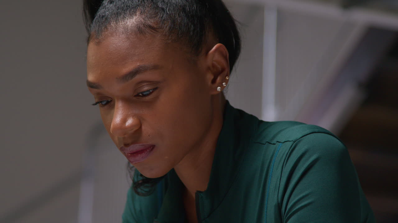 Close Up Portrait Of Determined Female Athlete Sport Training In Gym Sitting And Concentrating In Changing Room With Focused Expression