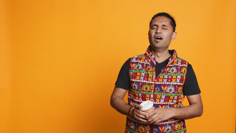 persona agotada bostezando, bebiendo café, aislada sobre el fondo del estudio