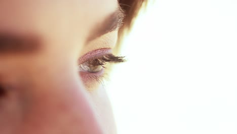 closeup of a woman's eyes sitting on the beach on a beautiful summer day