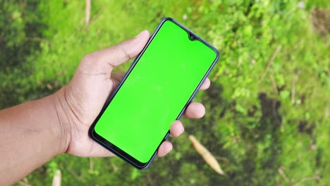 Rear-view-of-young-man-using-smart-phone-at-outdoor