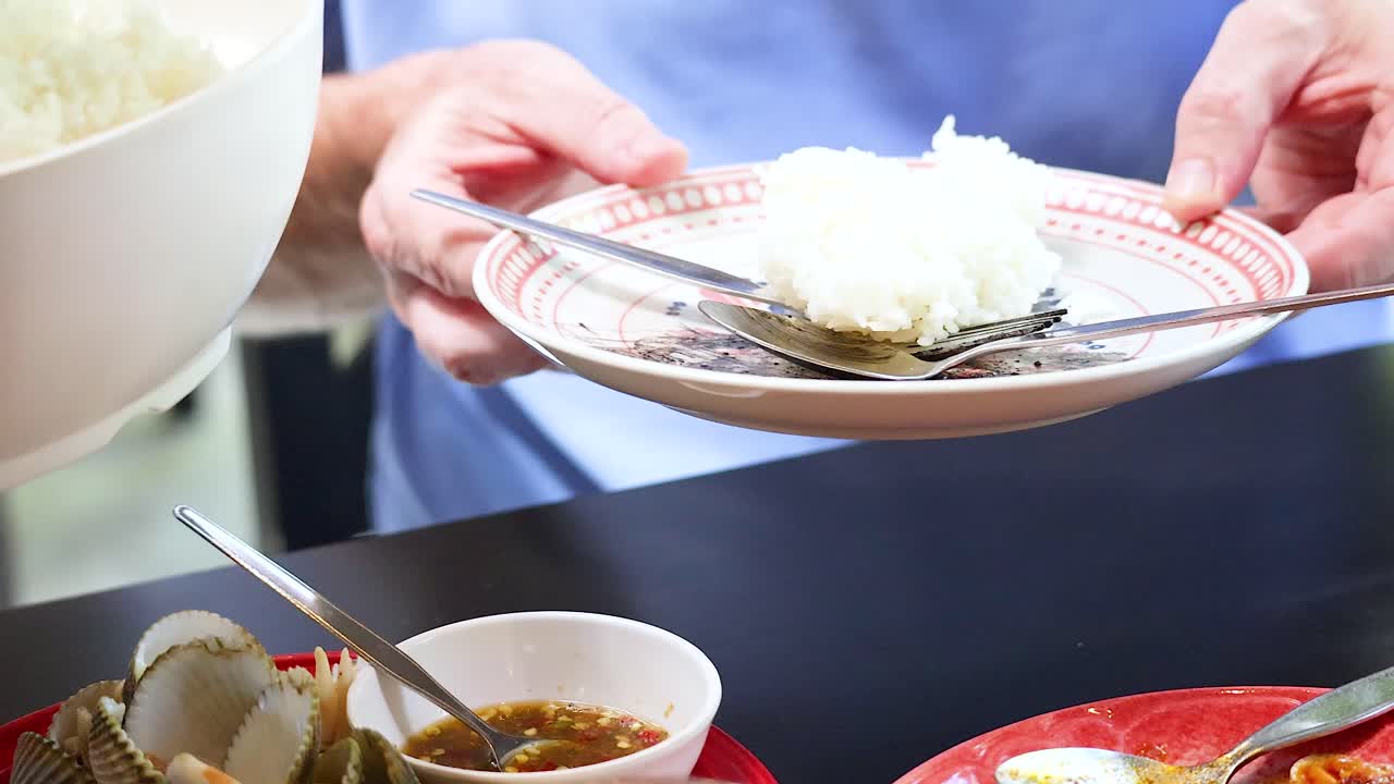 manos sirviendo arroz en el plato en la comida en phuket, tailandia