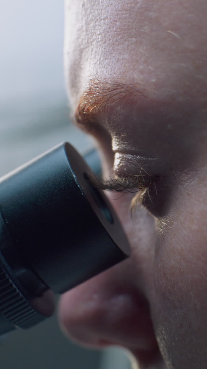 primer plano de un científico usando un microscopio