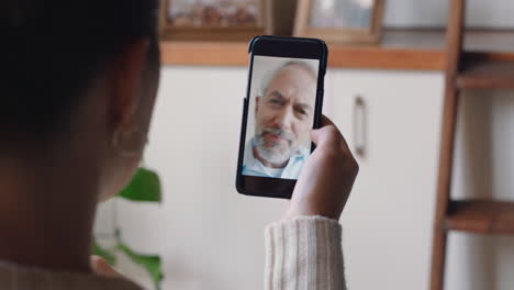 young woman having video chat using smartphone chatting to grandfather enjoying conversation sharing lifestyle communicating with mobile phone at home