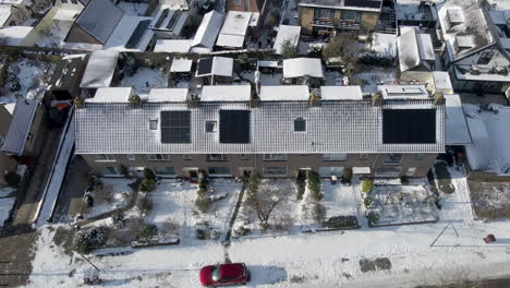 aerial dolly of solar panels of snow covered rooftops