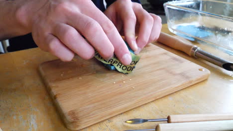 Un-Artista-Escultor-Lijando-Y-Puliendo-Una-Escultura-De-Arcilla-De-Una-Máscara-Hecha-A-Mano-En-Un-Estudio-Con-Papel-De-Lija-Húmedo-De-Grano-Fino-Para-Tallar-Y-Pulir-Su-Forma-Para-Que-Sea-Suave