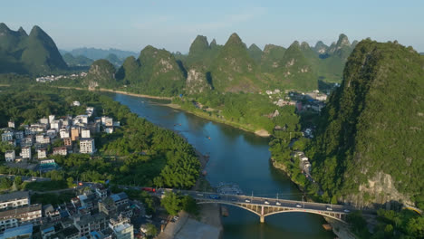 aerial view over the yangshuo bridge following the lijiang river, sunset in china