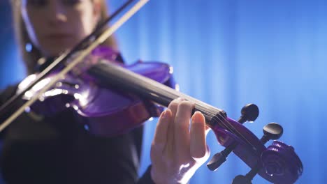 Close-up-of-musician-playing-violin-on-stage.