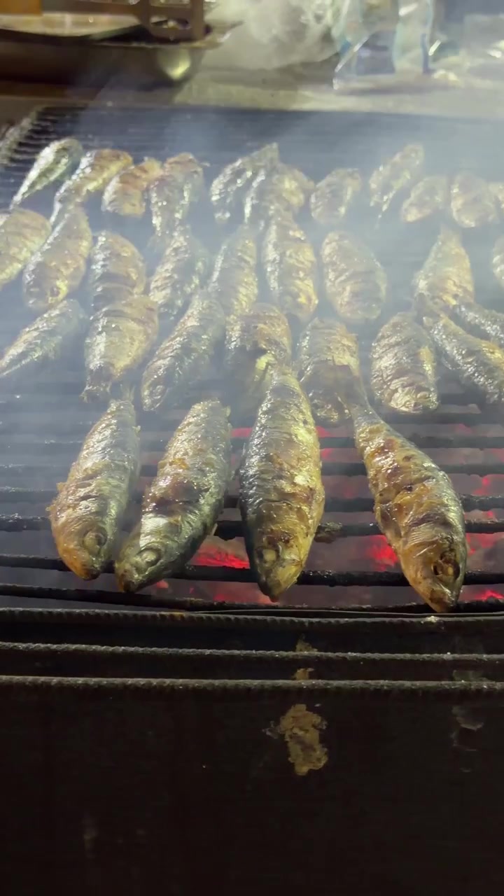 Sardine fresche alla griglia su barbecue a carbone
