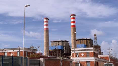 two chimneys for smoke evacuation near a road with circulating cars