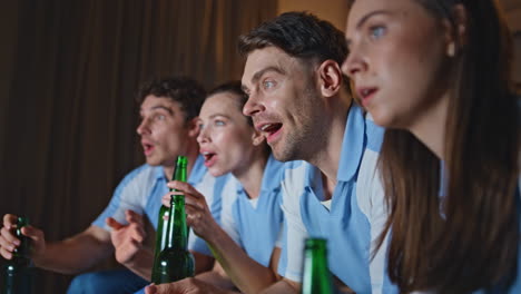 happy group watching championship on tv sharing beer close up. people rejoicing