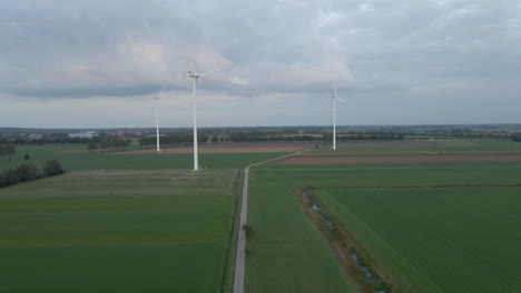 aerial of three spinning windmills in rural area