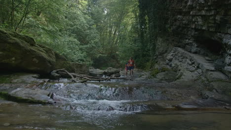 family hiking through a forest creek