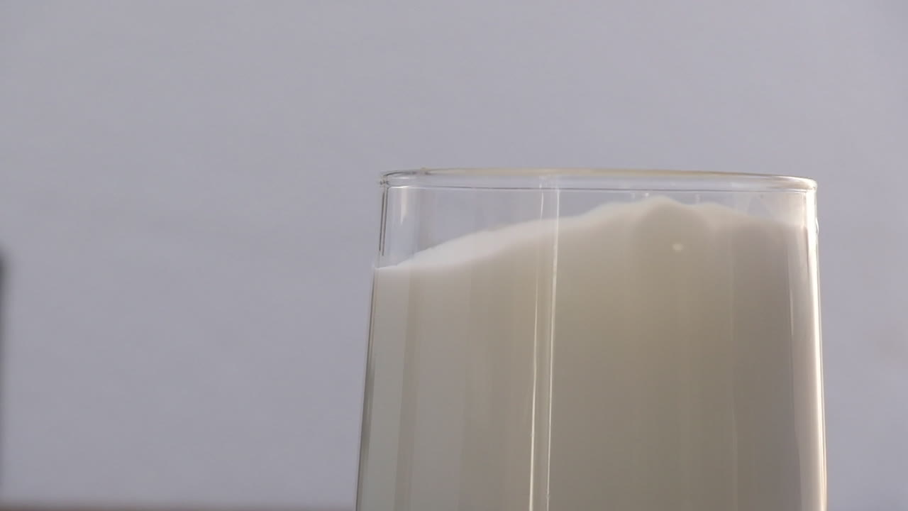 imágenes en cámara lenta de una galleta que se cae en un vaso de leche contra un fondo aislado