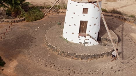 a woman is playing and running by the windmill of los molinos village