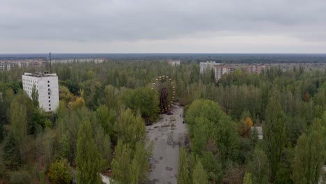 volando sobre el parque de atracciones desierto en pripyat, ucrania con vista de la rueda de la fortuna oxidada - desastre de chernobyl - drone aéreo