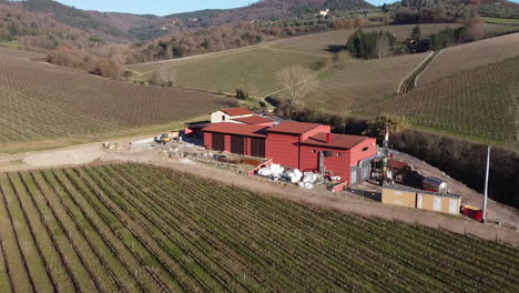 Vuelo-Aéreo-Sobre-Las-Colinas-Que-Rodean-La-Vid-De-La-Bodega-Chianti-Frescobaldi-En-Toscana,-Italia-Durante-El-Día-Soleado