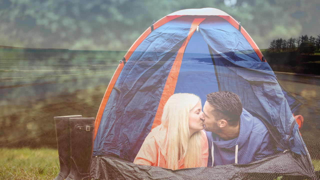 평화로운 야외 풍경 위에 텐트에서 키스하는 커플