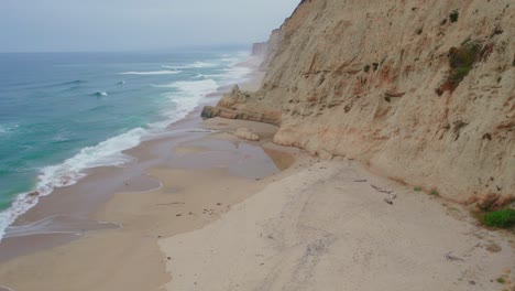 flying along cliffs as marine layer blows in california beach drone