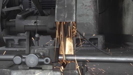 cerrar la máquina de corte de acero automática y chispas mientras moliendo hierro en la fábrica industrial. movimiento lento