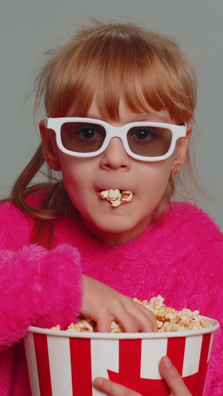 Bambina eccitata bambina che mangia popcorn guarda serie televisiva sport gioco film online social media film