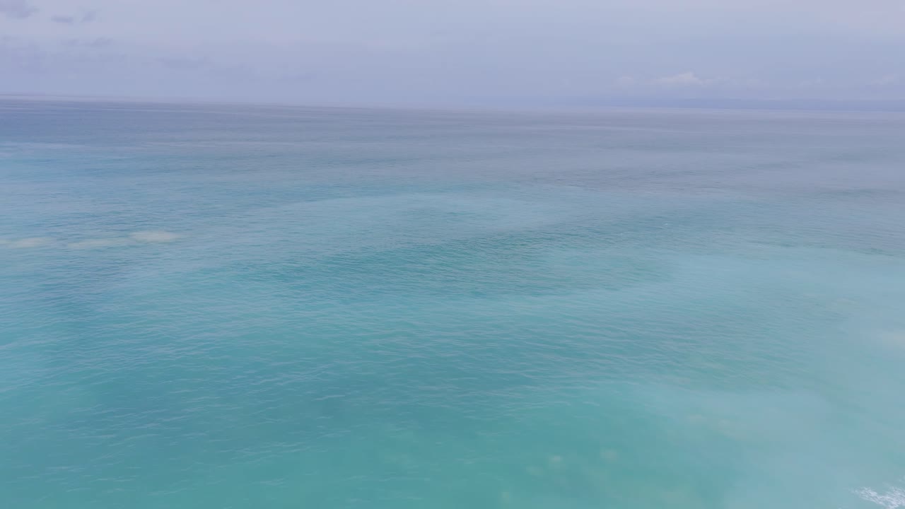Vista aérea de ondas do oceano turquesa quebrando em uma praia tropical