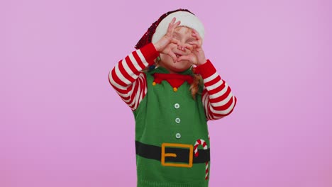 una chica sonriente con un disfraz de elfo de navidad hace un gesto de corazón demuestra un signo de amor expresa sentimientos