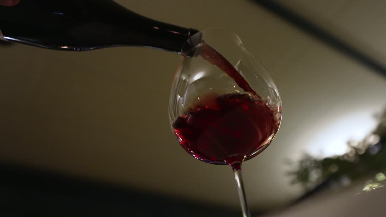 Red wine pouring, slow motion with lots of bokeh while dinner in Italy.