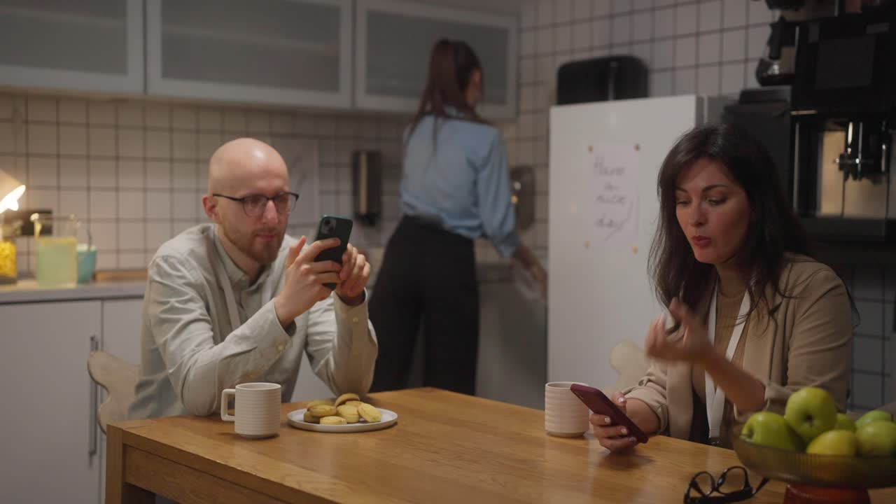 People in a kitchen using smartphones