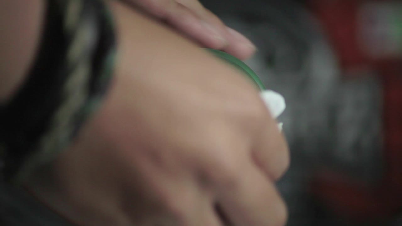 Cleaning dust from skateboard wheel with tissue and oil and spinning it