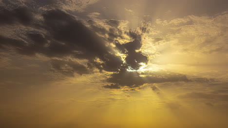 breathtaking golden view timelapse of sun rays shining through fluffy clouds in a golden sky, creating a serene and tranquil atmosphere