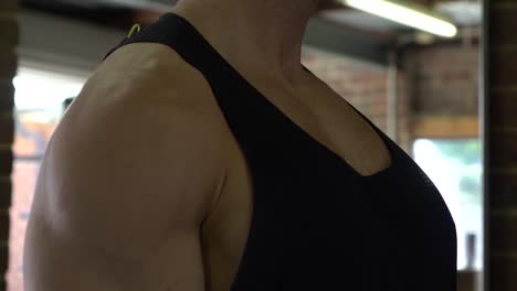 Muscly-man-in-home-gym-exercising-close-up-dumbbell-shoulder-raise