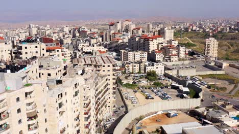 aerial view of a city with densely packed buildings and a concrete security wall