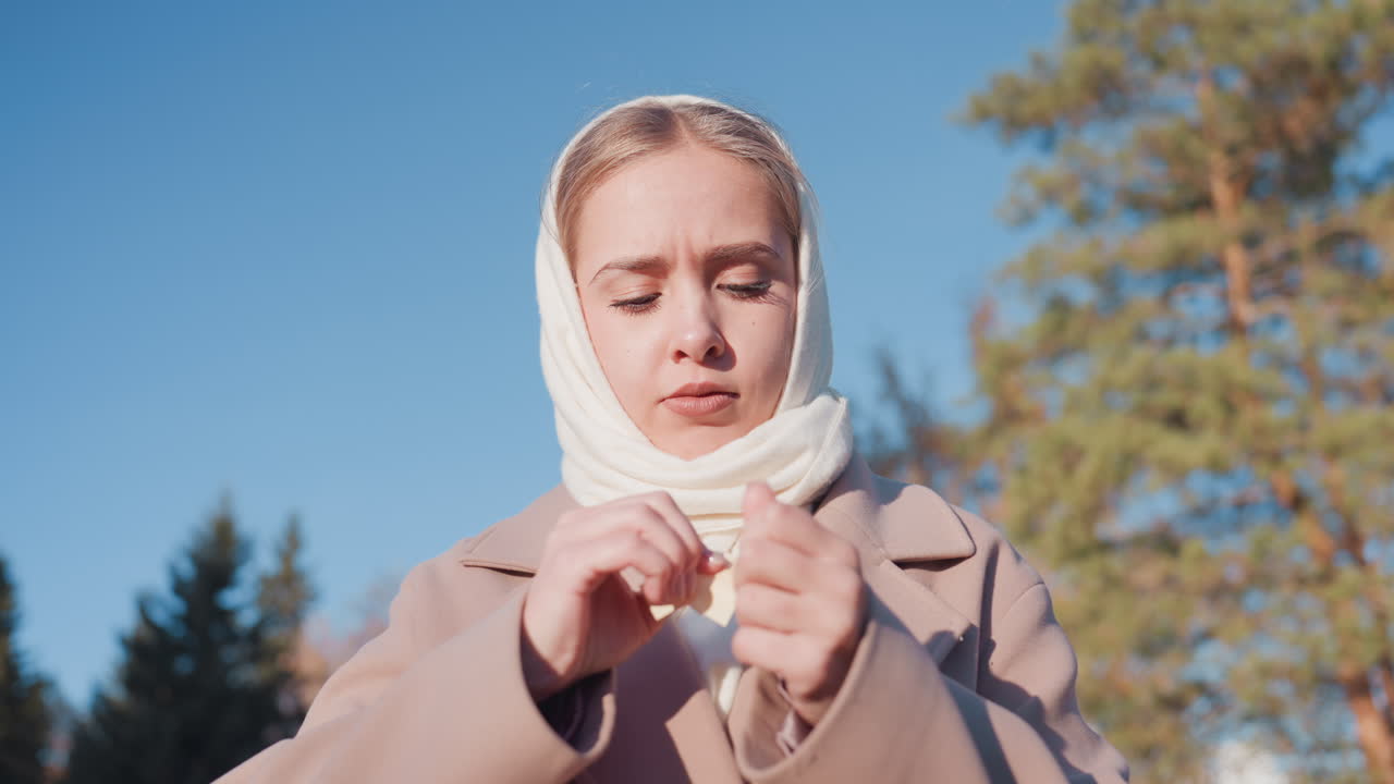 Valkoihoinen nainen repii ja vapauttaa viestin mäntymetsässä kirkkaan sinisen taivaan alla, yllään huivi ja beige takki. Hitaat ilmeikkäät eleet, paperi leijailee auringonvaloon. Hiljainen pohdiskeleva tunnelma.