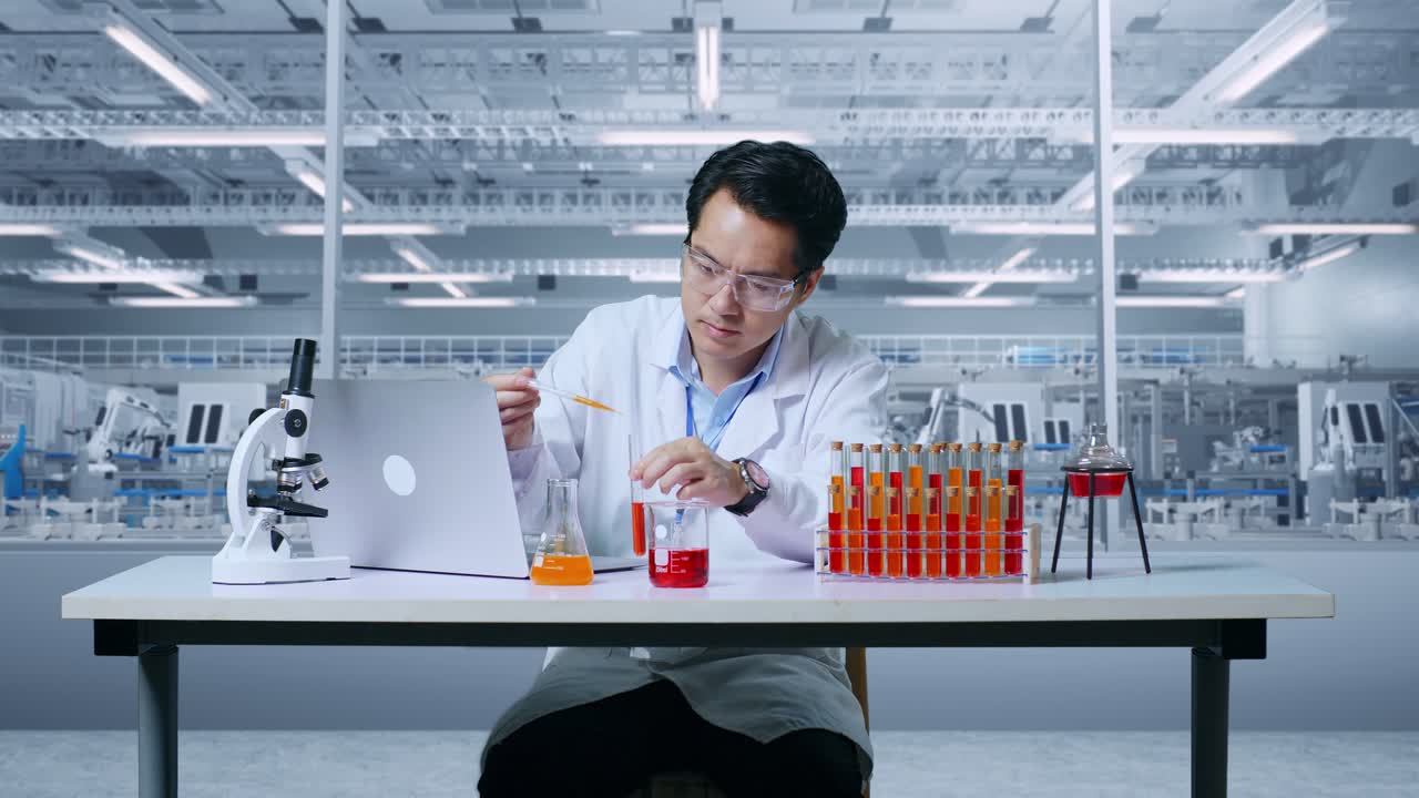 아시아의 한 과학자가 실험관으로 실험을 하고, 그의 성공을 축하하며, 실험실에서 현미경이 있는 테이블 위에 노트북으로 타이핑을 하고, 실험관에서 연구 결과를 분석하고, 실험관 플을 분석하고 있다.