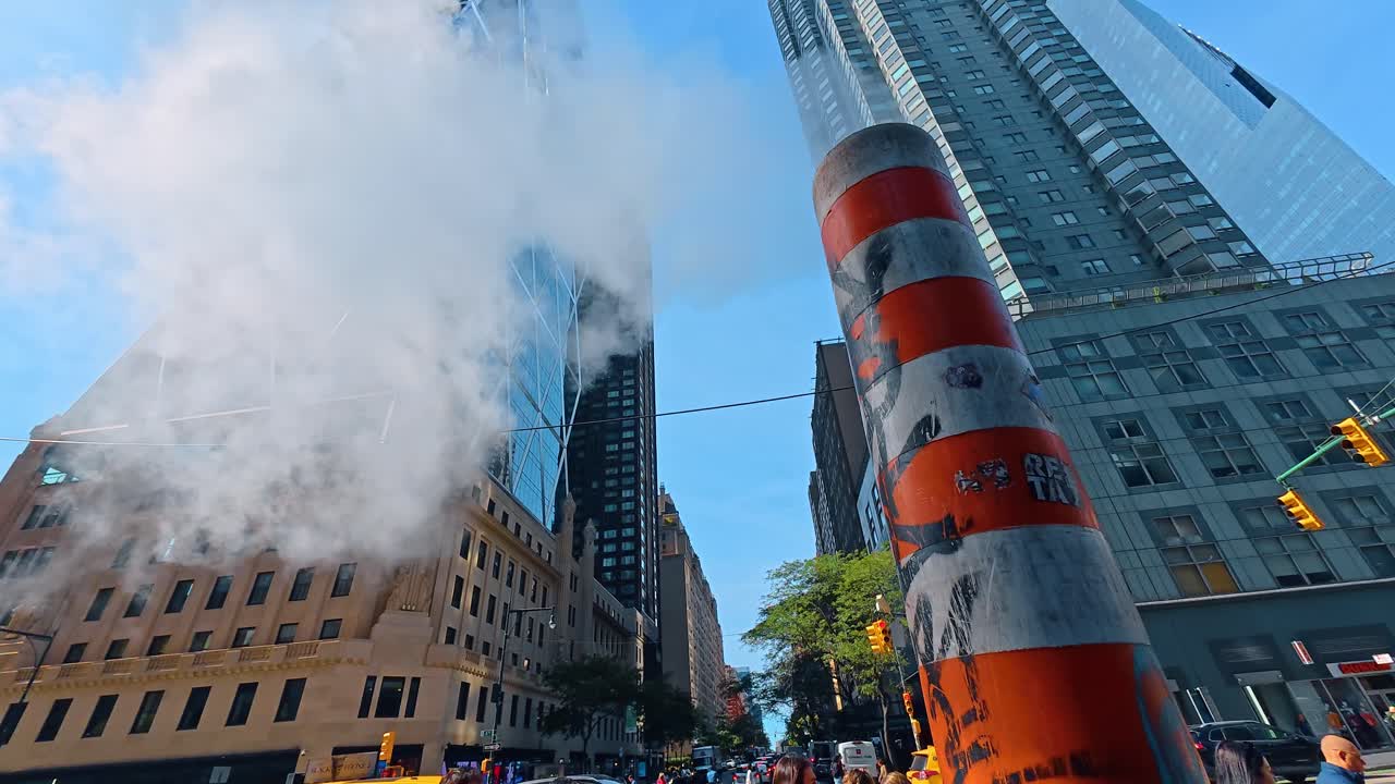 Nueva York, EE. UU., 7 de agosto de 2025: Intersección concurrida en Manhattan con tubería de vapor y peatones. Gente cruzando la 8ª Avenida en la ciudad de Nueva York con vapor saliendo de una tubería de servicios públicos en un día soleado