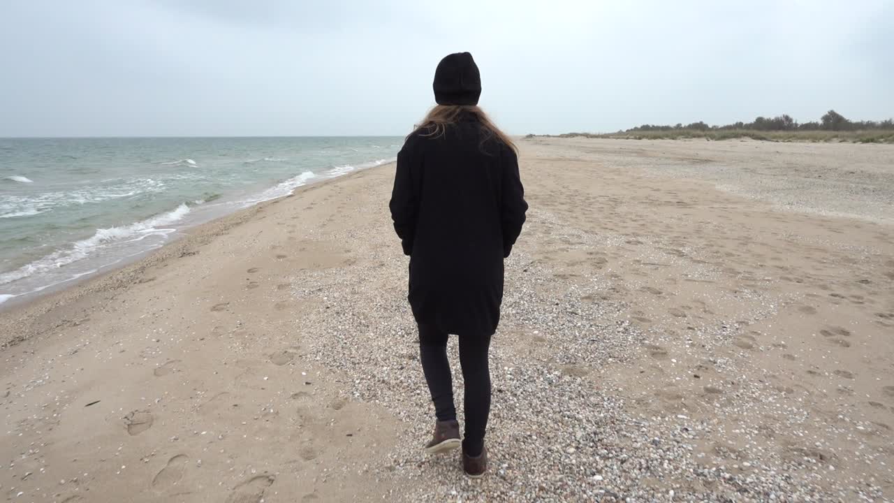 少女が浜辺を歩く。浜辺での撮影。