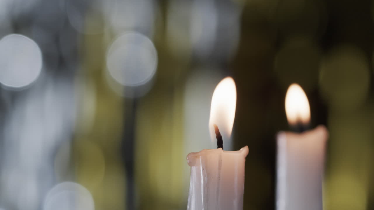 Video di candele bianche con fiamme bianche e spazio per il testo con effetto bokeh su sfondo nero