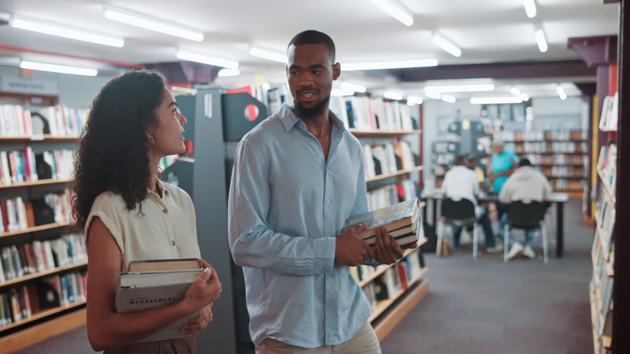 Young Man and Woman Talking While Walking Through Library with Books