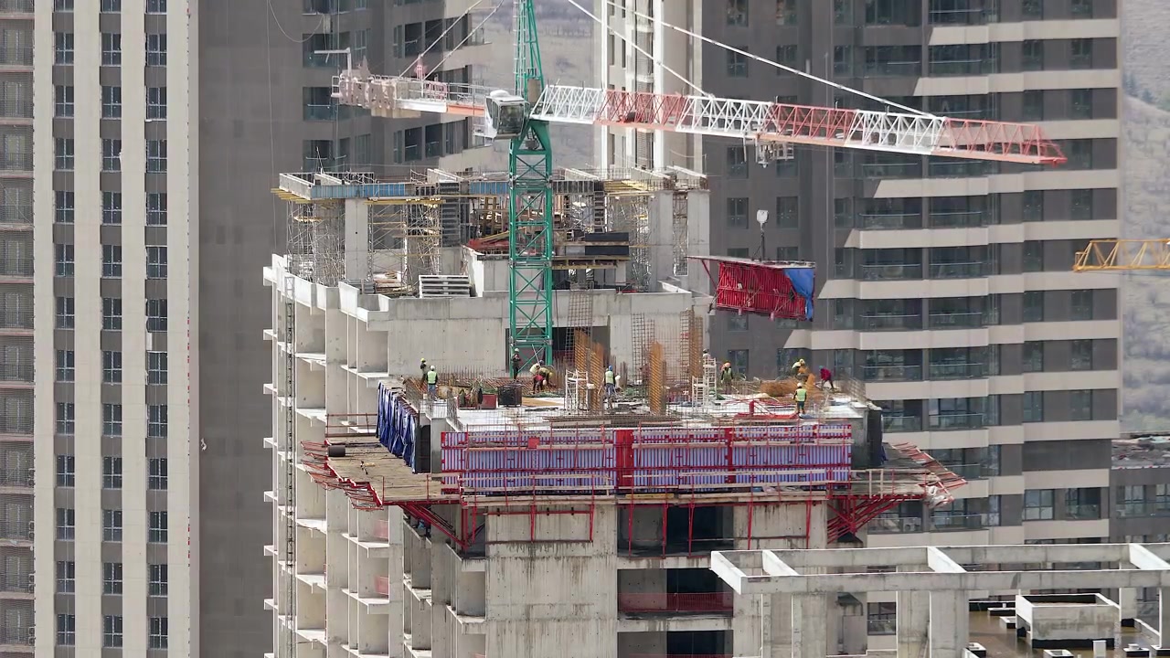 Trabajadores de la construcción edificando un rascacielos de gran altura con grúa torre