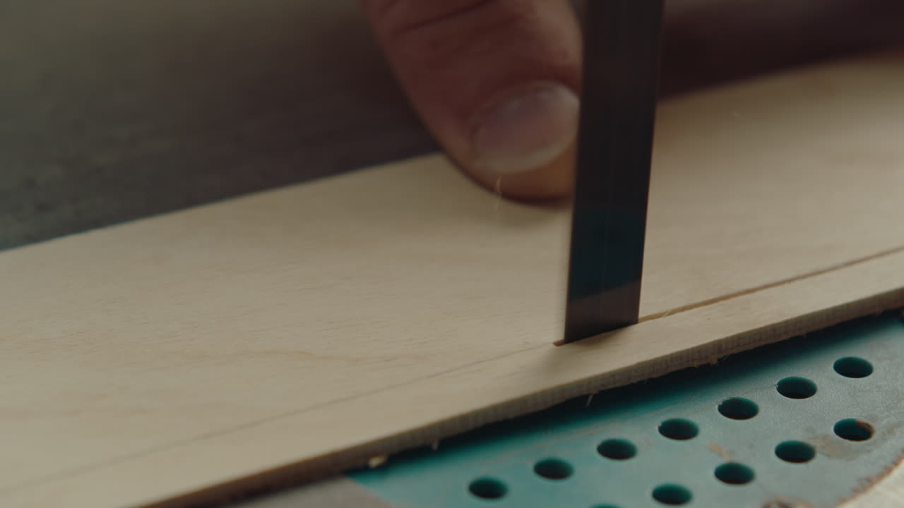 Hands of Woodworker Cutting Plank with Bandsaw