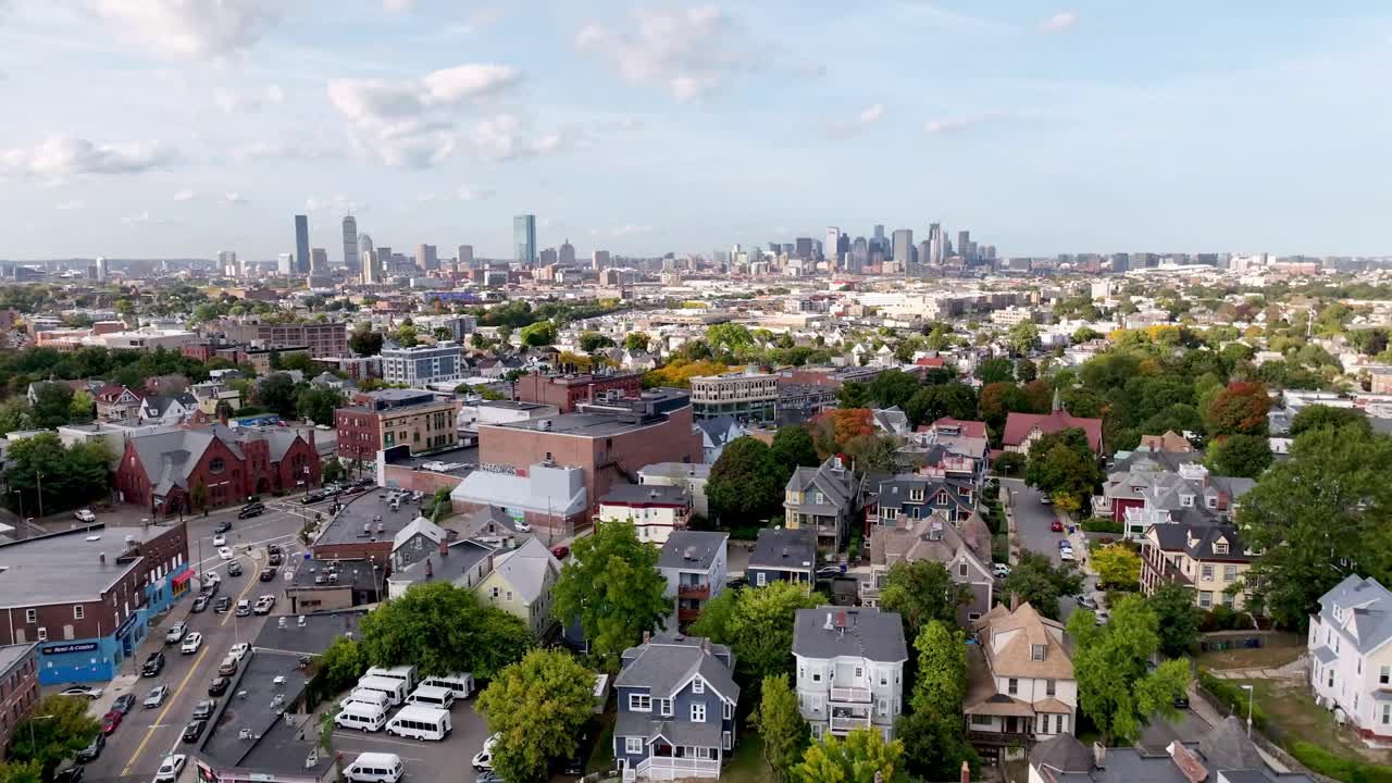 aerial pullout over Boston Massachusetts homes and neighborhoods with skyline in background