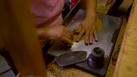 Close-up-artisan-hands-rolling-luxury-cigar-from-tobacco-leaves,-traditional-handmade-cigars-production