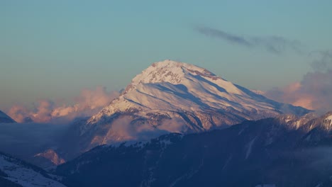 marvel at the breathtaking sunrise over a snow-covered mountain range silhouette from this stunning drone viewpoint